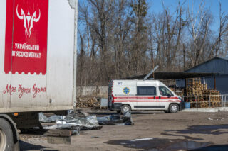 Автомобіль швидкої допомоги поруч із завалами пошкодженої будівлі підприємства після атаки російського безпілотника на м'ясокомбінат у Харкові, 11 березня 2026 року