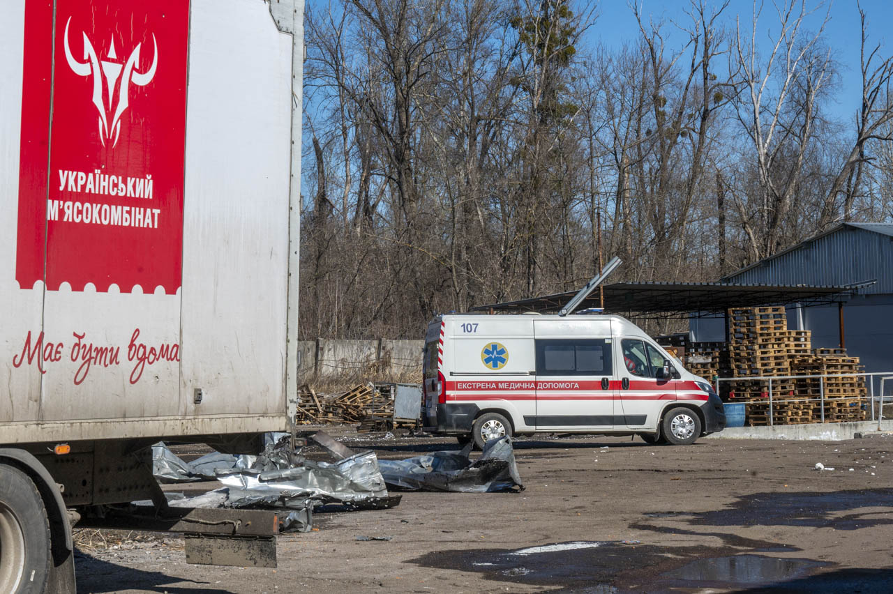 Автомобіль швидкої допомоги поруч із завалами пошкодженої будівлі підприємства після атаки російського безпілотника на м'ясокомбінат у Харкові, 11 березня 2026 року