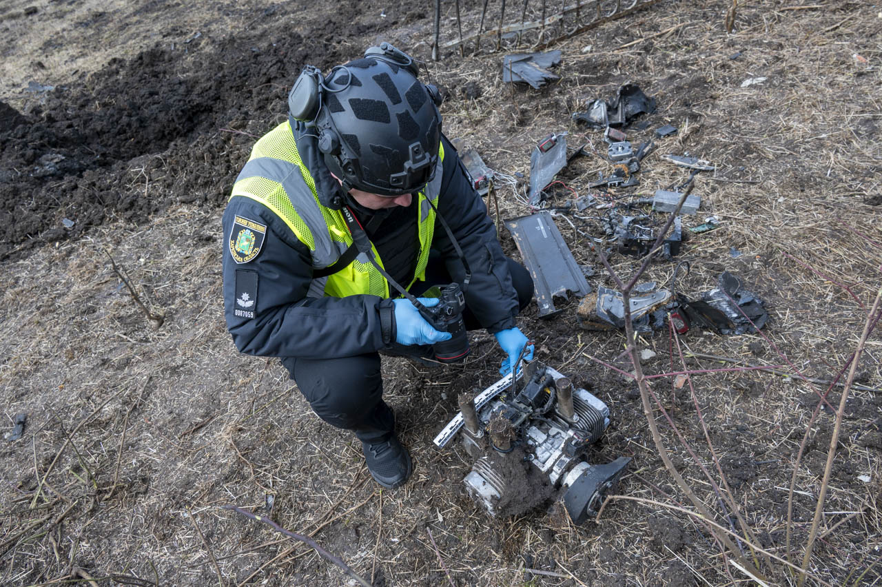 Експерт-криміналіст поліції оглядає уламки російського дрону біля місця влучання у Харкові 16 березня 2026 року під час слідчих дій