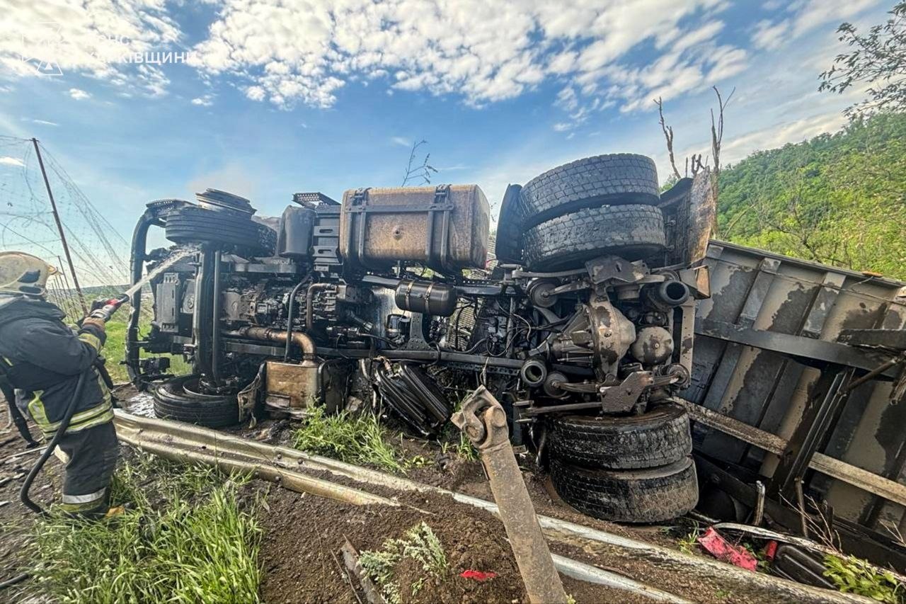 Пожежник ДСНС біля згорілої вантажівки на окружній дорозі Харкова після удару російського FPV-дрона